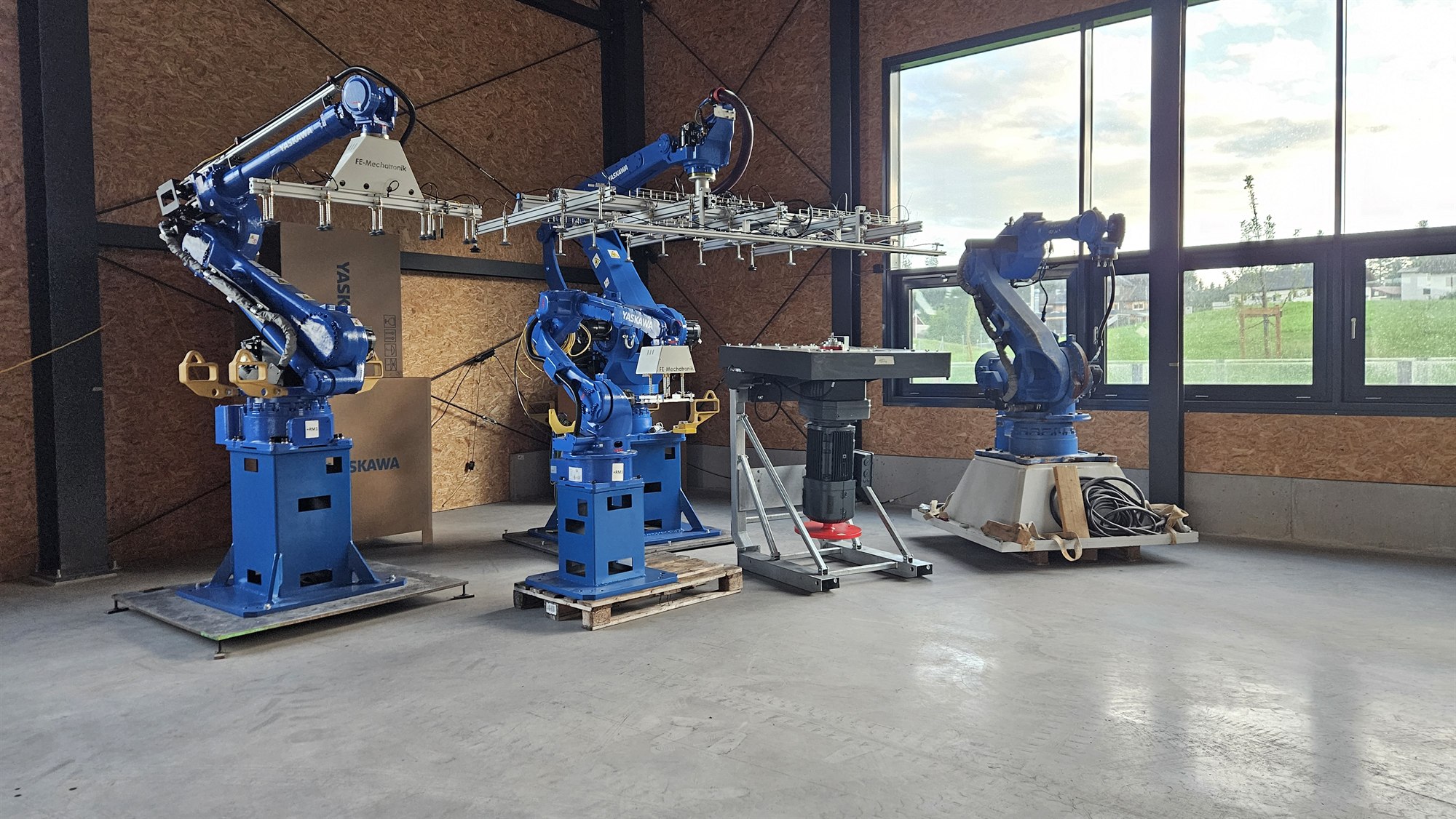 Mehrere Yaskawa-Industrieroboter und Automatisierungskomponenten in der Werkshalle